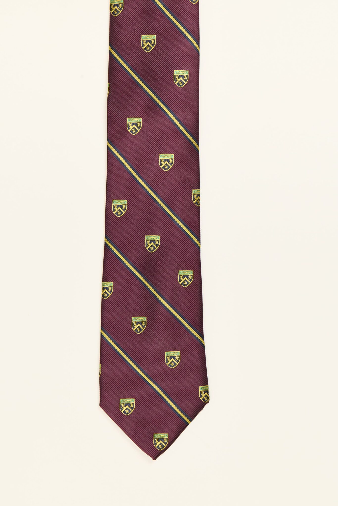 Corbata burdeos con rayas diagonales y escudos bordados, modelo PuroEgo