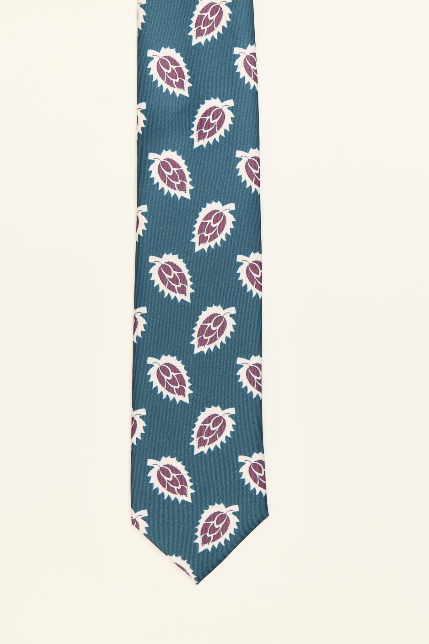 Corbata verde agua con estampado de hojas sobre fondo oscuro, modelo PuroEgo