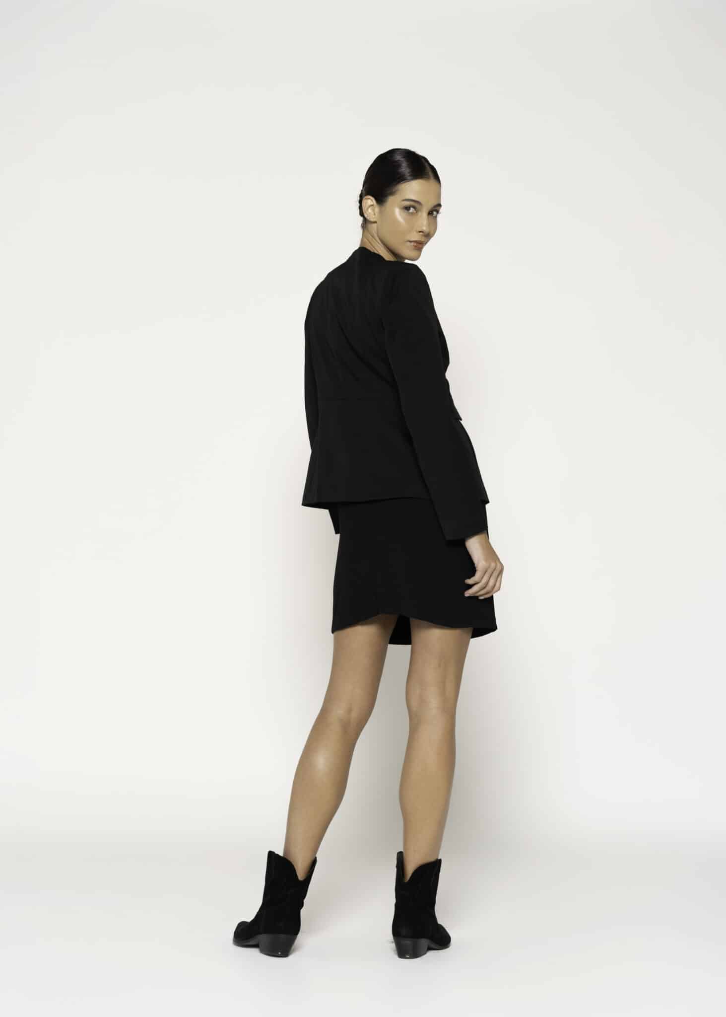 Chaqueta negra de corte recto con cuello redondo y botones dorados, modelo Formentera, frente.
