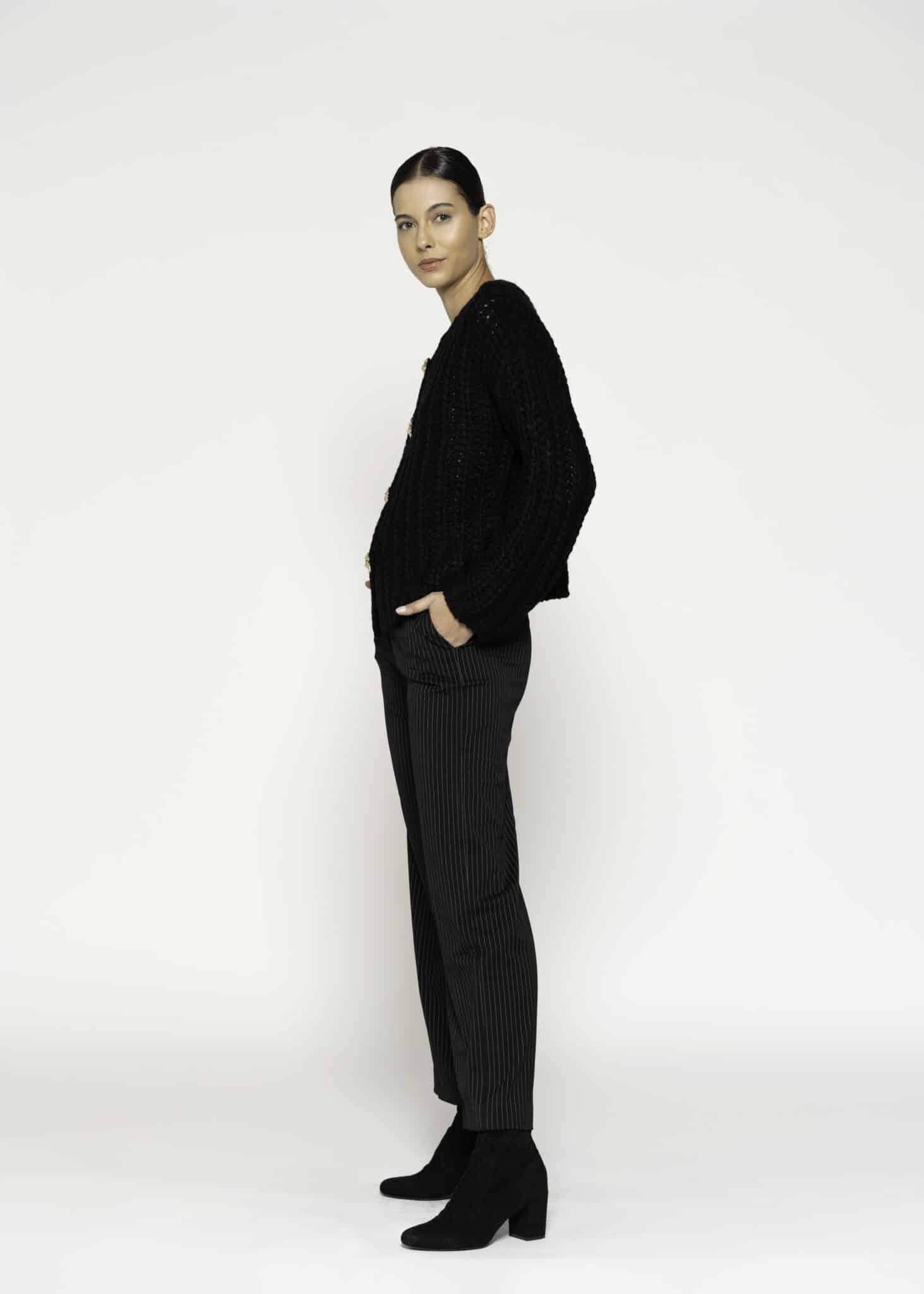 Chaqueta tejida negra con textura bouclé y cuatro botones dorados, modelo Formentera, frente.