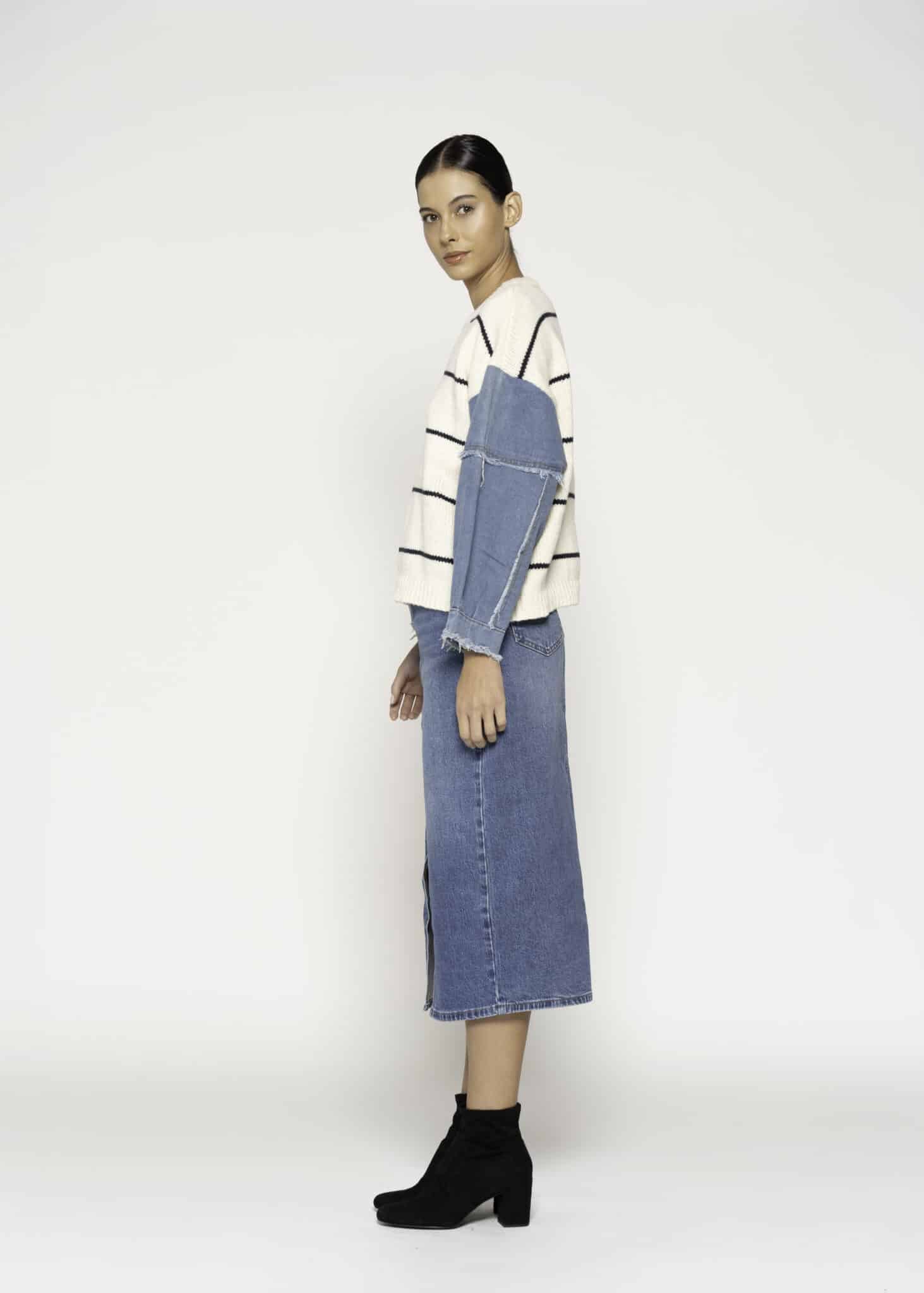 Sweater tejido a rayas negras y crudo con mangas de mezclilla azul, modelo Formentera, frente completo.