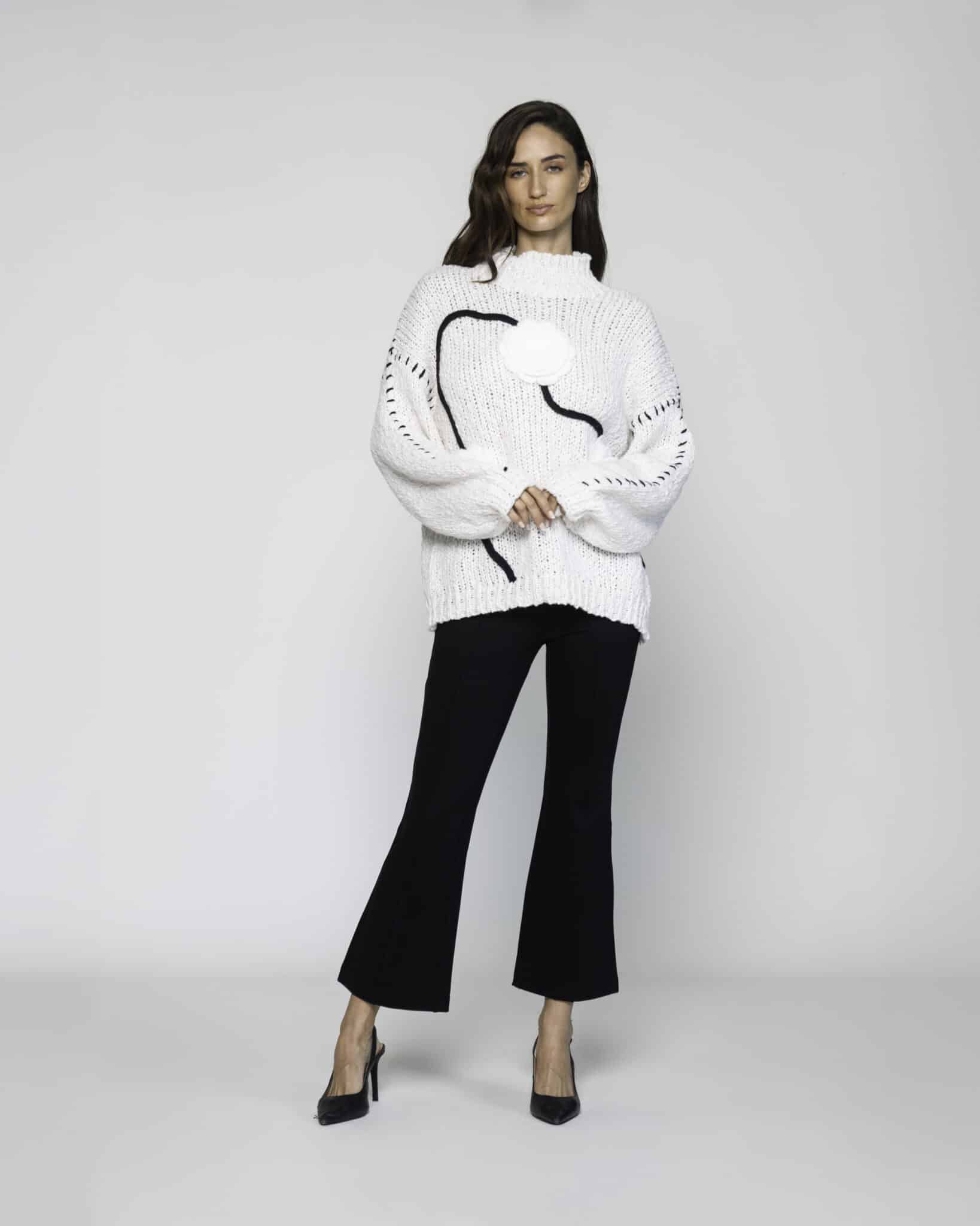 Sweater blanco de tejido grueso con cuello alto y líneas negras en el frente, modelo Formentera.