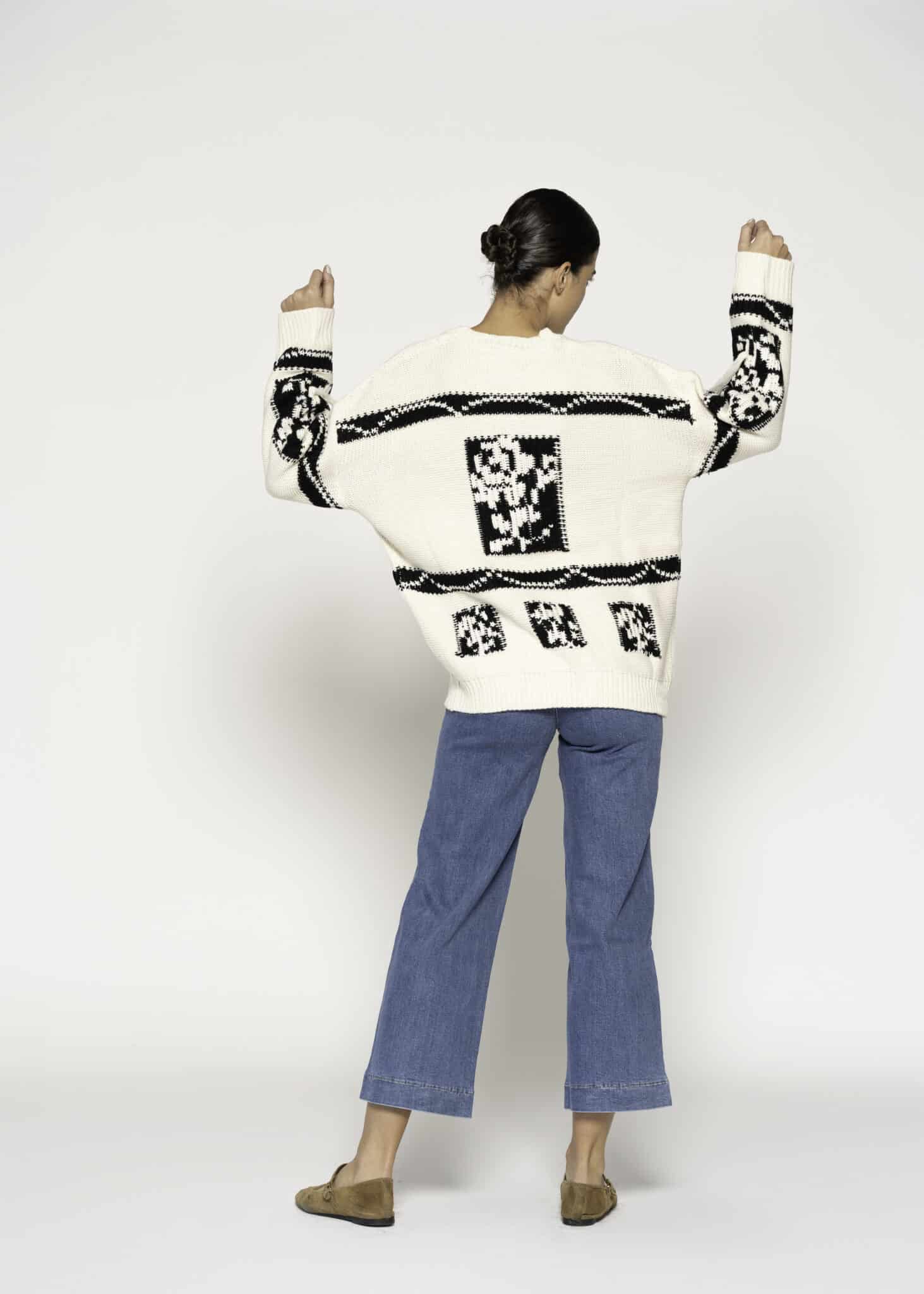 Sweater tejido crudo con diseño gráfico negro en frente y mangas, modelo Formentera, vista frontal.