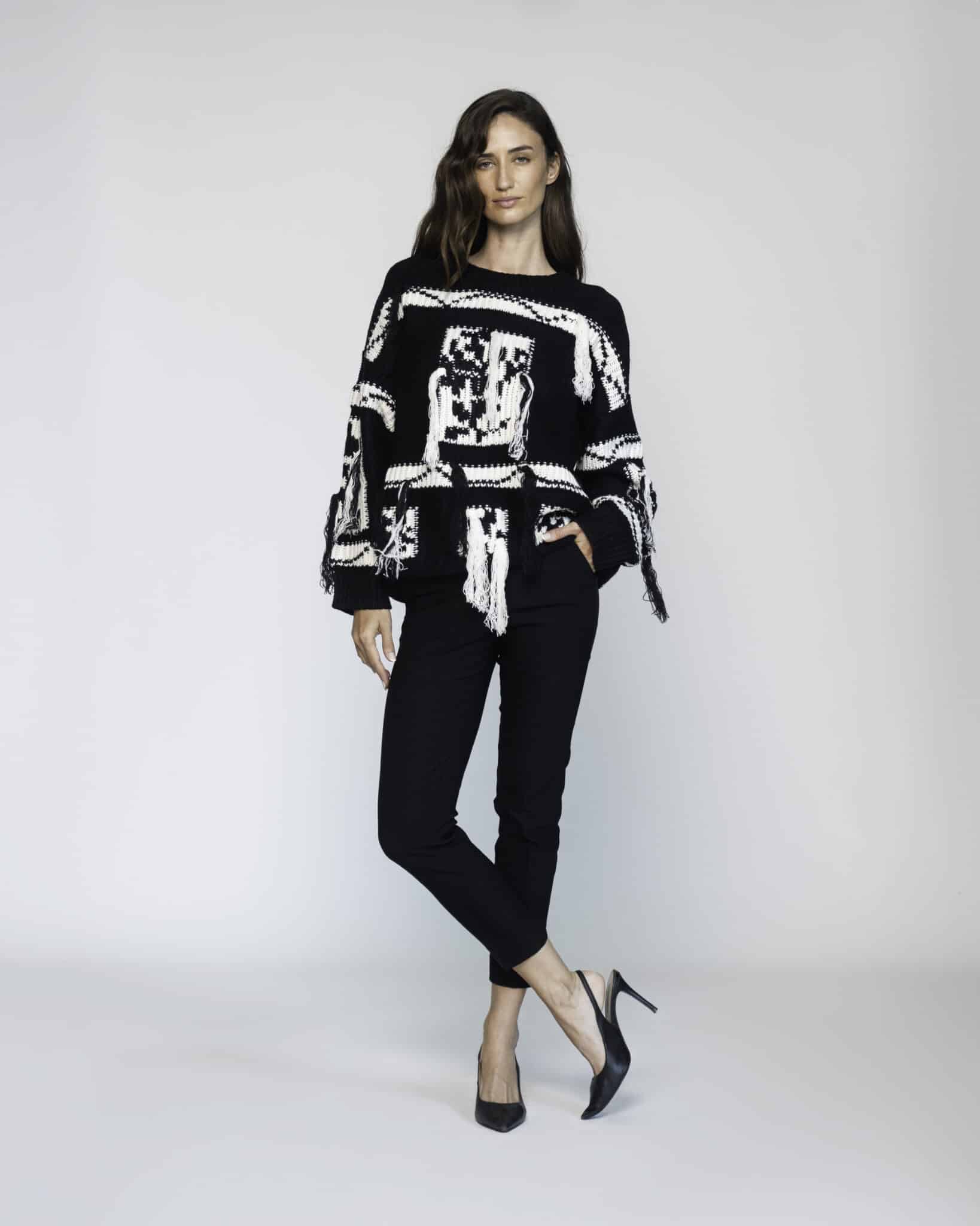 Sweater negro de punto grueso con diseño gráfico blanco en frente y mangas, modelo Formentera, vista frontal.