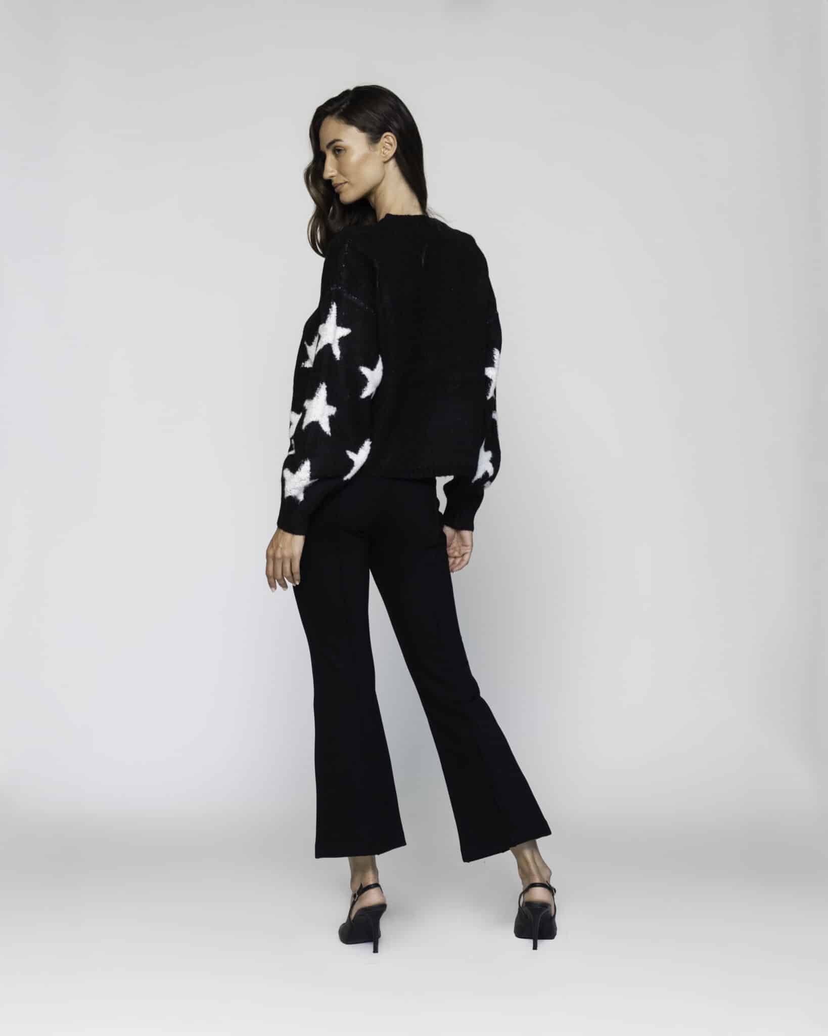 Sweater negro de tejido de punto con estrellas blancas bordadas, cuello redondo y manga larga, modelo Formentera.